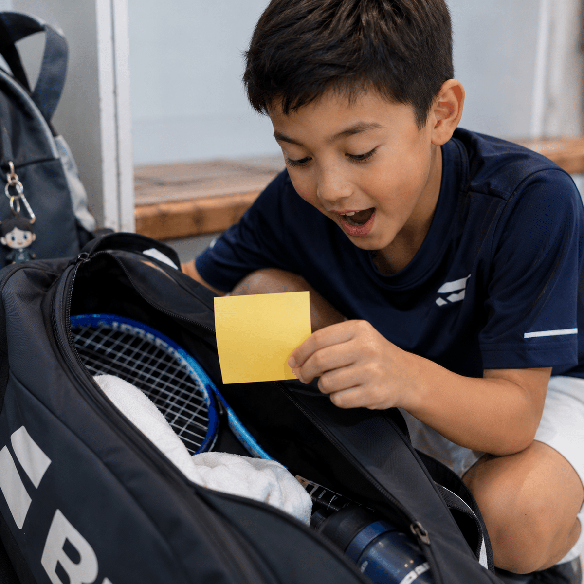 A handwritten Tiny Note reading 'You are Loved' tucked inside a child's lunchbox